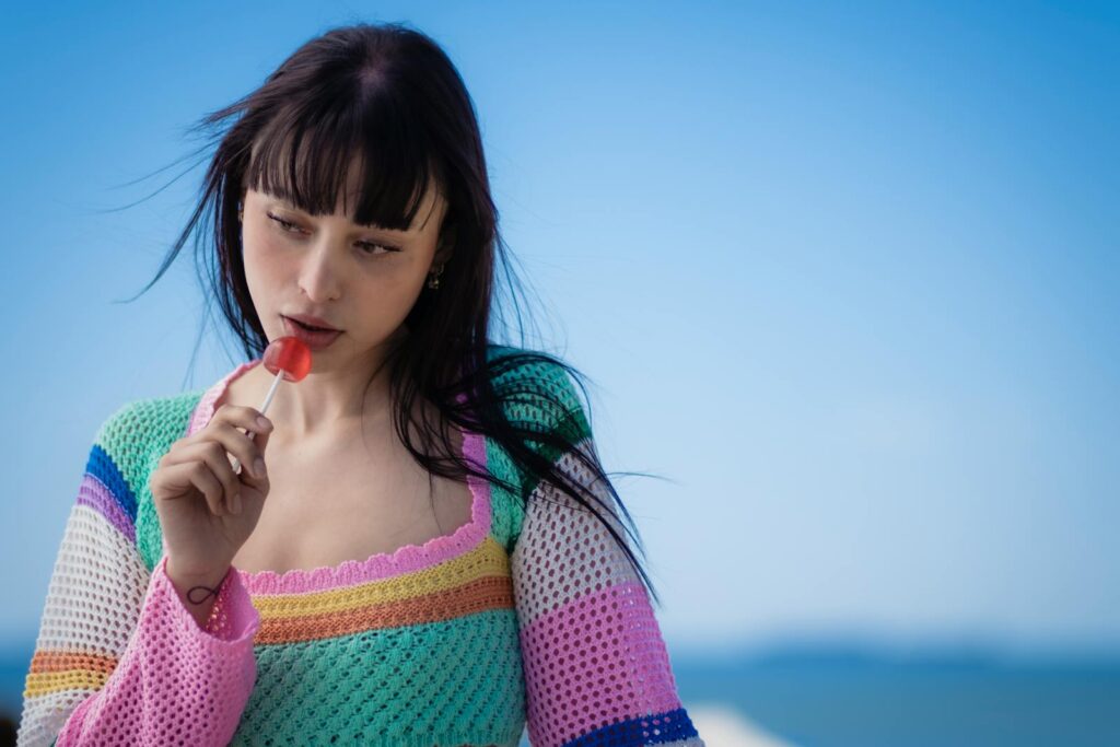 Woman Wearing Crochet Long Sleeves Holding a Lollipop